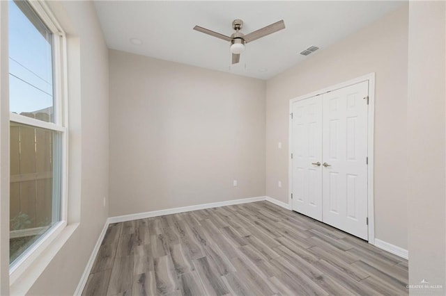 unfurnished bedroom featuring visible vents, light wood-style flooring, and baseboards