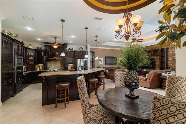 tiled dining room featuring a raised ceiling, crown molding, and a chandelier