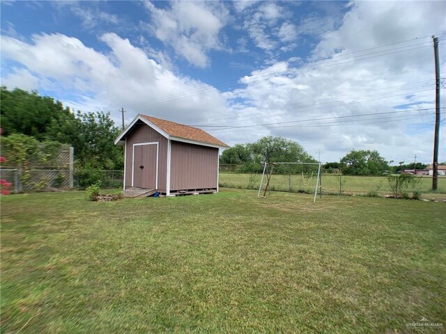 205 W Beck St, Harlingen, TX 78550 - fenced backyard featuring a storage unit and a playground