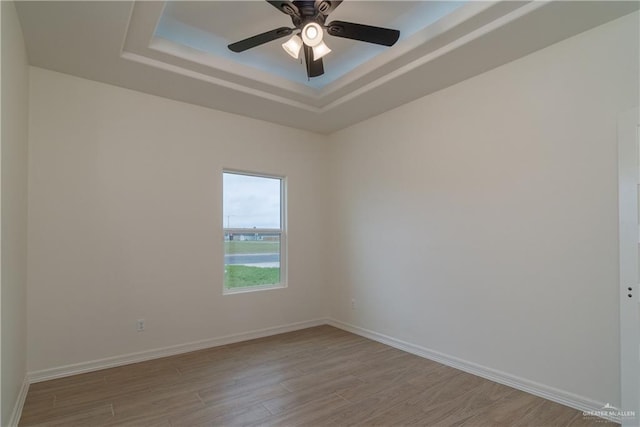 536 Pearl St, Edinburg, TX 78539 - empty room featuring a tray ceiling, light wood-style floors, ceiling fan, and baseboards