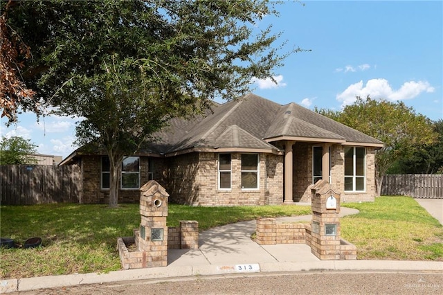 313 Royal St, Edinburg, TX 78539 - ranch-style house featuring brick siding, roof with shingles, a front lawn, and fence
