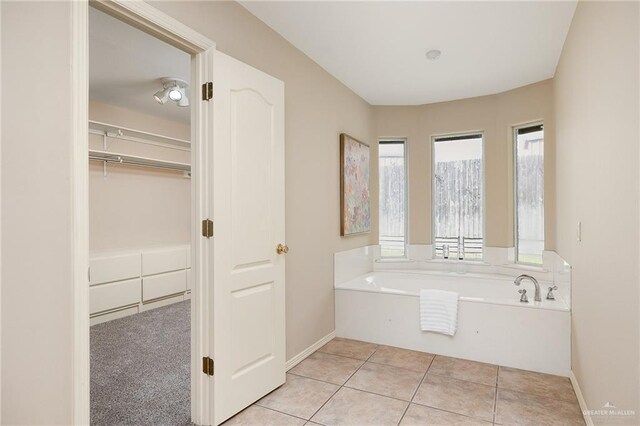 313 Royal St, Edinburg, TX 78539 - bathroom with a bath, baseboards, a spacious closet, and tile patterned flooring