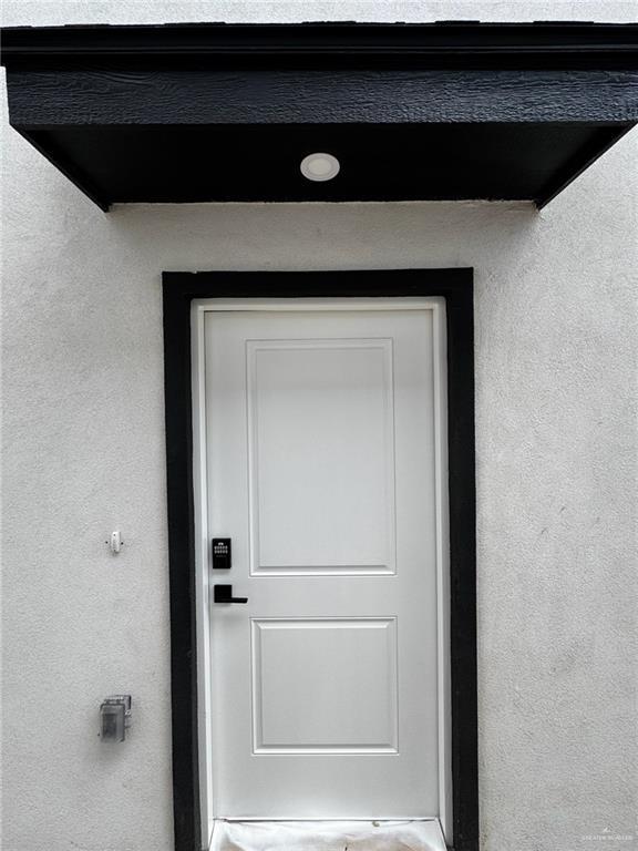 2809 Alpha Rd, Weslaco, TX 78596 - doorway to property featuring stucco siding