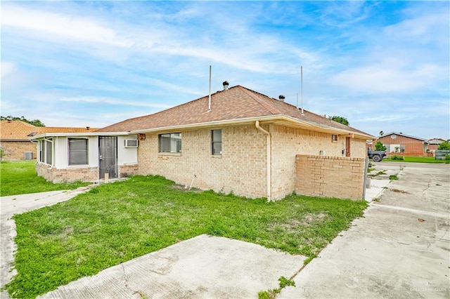 back of house featuring a yard and an AC wall unit