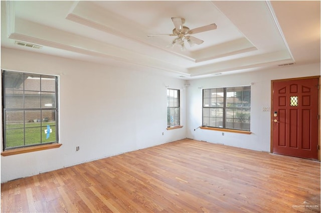 interior space with ceiling fan, light wood-type flooring, and a tray ceiling