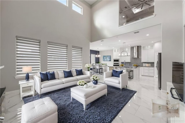 living room featuring a chandelier, sink, and a towering ceiling