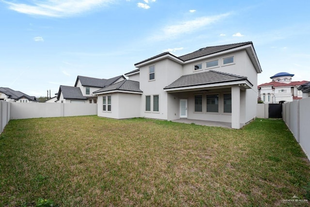 rear view of property with a patio and a lawn