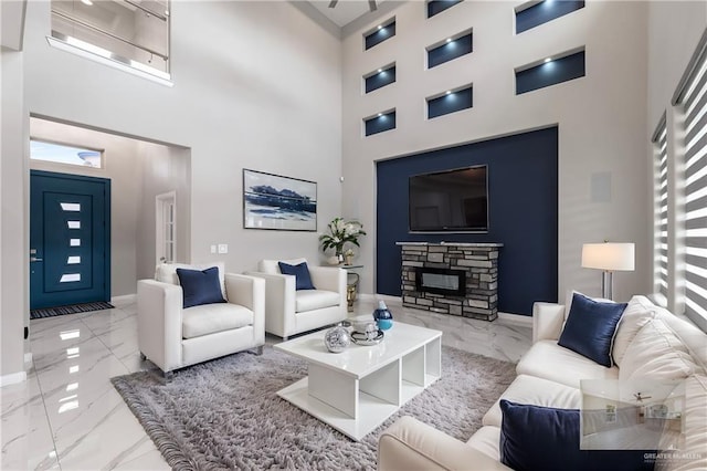 living room with a fireplace and a towering ceiling