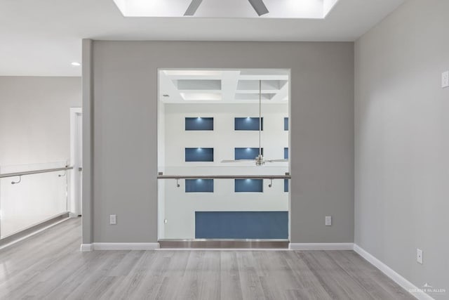 interior space featuring coffered ceiling, ceiling fan, beamed ceiling, and light wood-type flooring