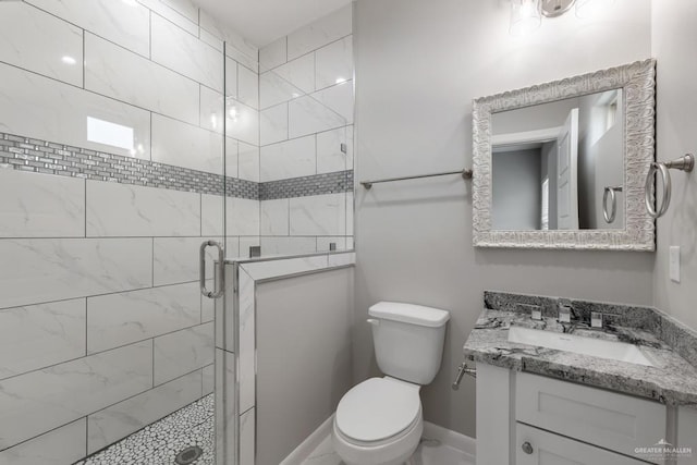bathroom featuring an enclosed shower, vanity, and toilet