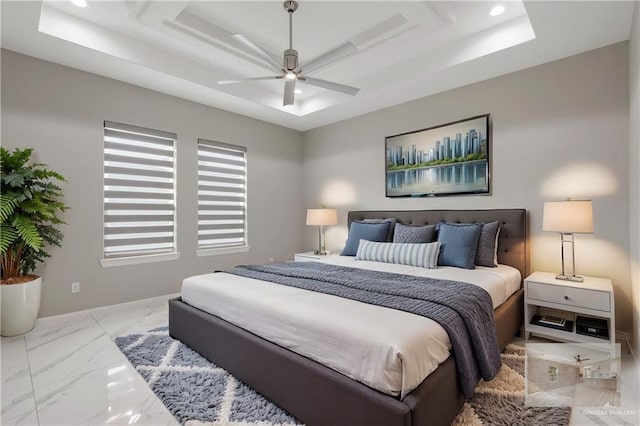 bedroom featuring ceiling fan and a raised ceiling