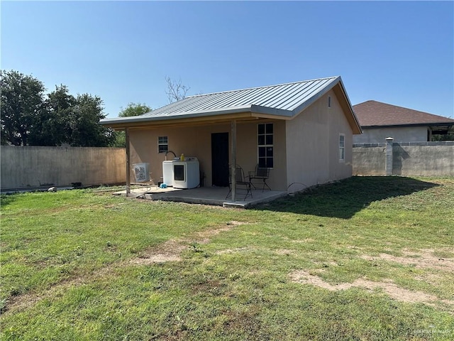 rear view of property featuring a lawn, ac unit, a patio, and washer / dryer