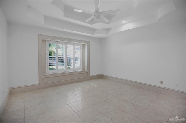 unfurnished room featuring a raised ceiling, light tile patterned floors, ceiling fan, baseboards, and recessed lighting