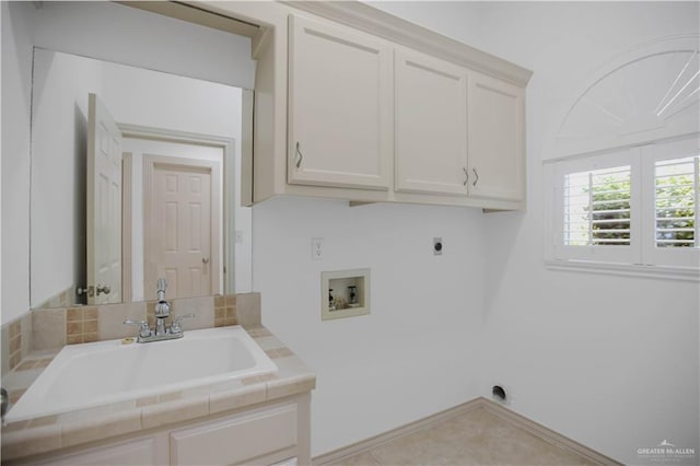 clothes washing area with electric dryer hookup, cabinet space, washer hookup, and baseboards