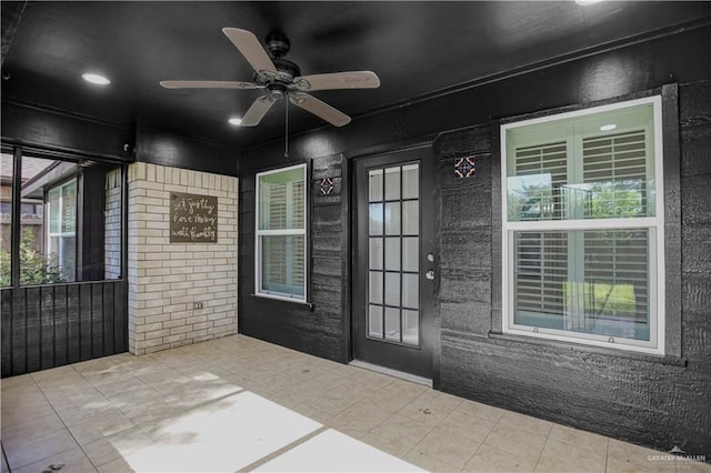 doorway to outside with a ceiling fan and tile patterned flooring
