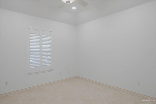 spare room with a ceiling fan and baseboards
