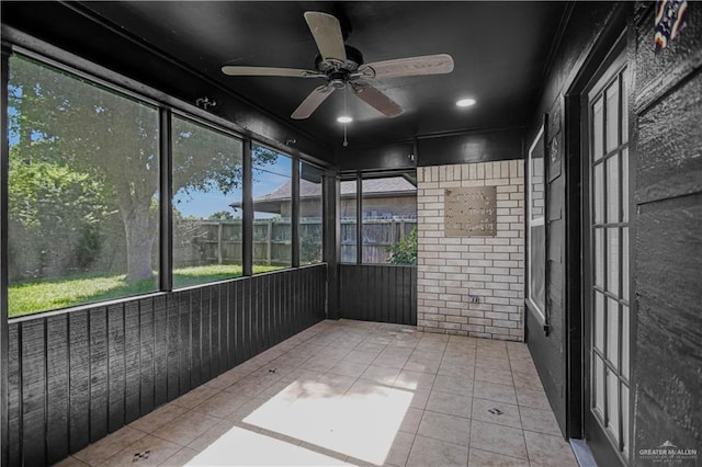 unfurnished sunroom with ceiling fan