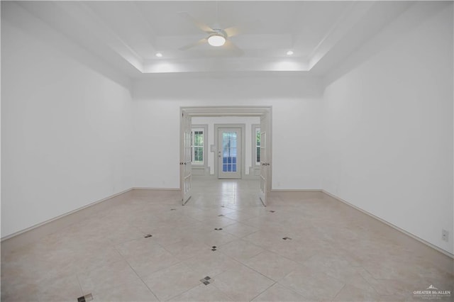 unfurnished room featuring a tray ceiling, a ceiling fan, recessed lighting, baseboards, and light tile patterned floors