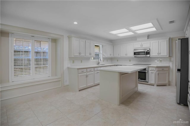 kitchen with stainless steel appliances, a sink, light countertops, tasteful backsplash, and light tile patterned flooring
