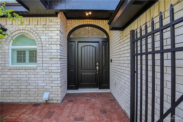 view of exterior entry featuring brick siding