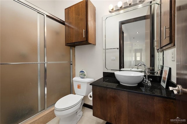 bathroom featuring vanity, toilet, a shower with shower door, and tile patterned flooring