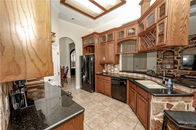 kitchen featuring arched walkways, brown cabinets, visible vents, a sink, and black appliances