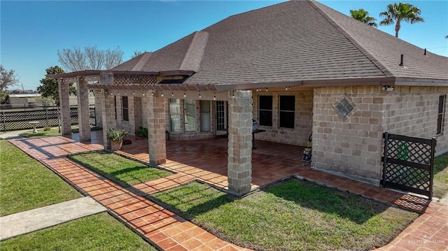 back of property featuring roof with shingles, fence, a yard, a patio area, and a pergola