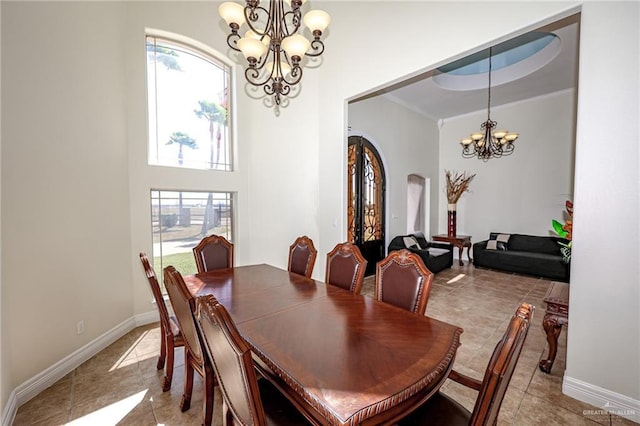 dining space with baseboards, arched walkways, crown molding, a notable chandelier, and light tile patterned flooring