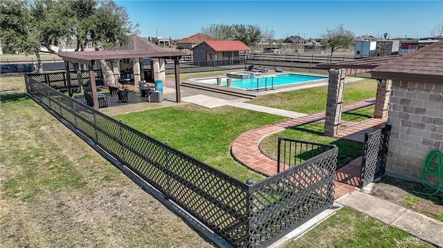 exterior space with a pool with connected hot tub, a lawn, and fence