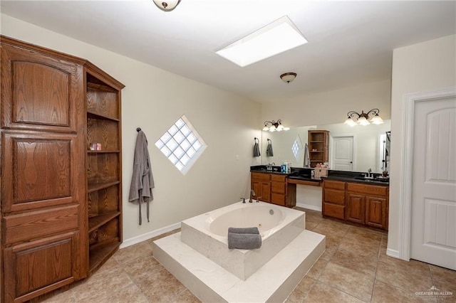 full bath featuring a garden tub, vanity, baseboards, and tile patterned floors