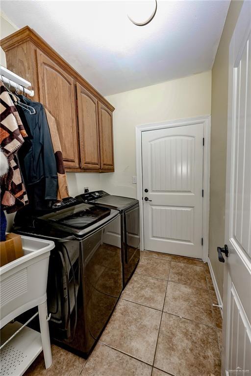 washroom featuring light tile patterned floors, cabinet space, and washer and dryer