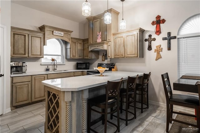 kitchen with kitchen peninsula, black appliances, sink, pendant lighting, and a breakfast bar area