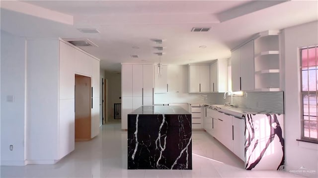 kitchen featuring white cabinetry, sink, and backsplash