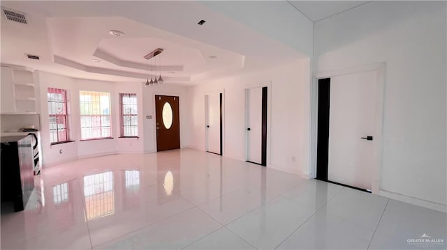 tiled foyer entrance featuring a tray ceiling