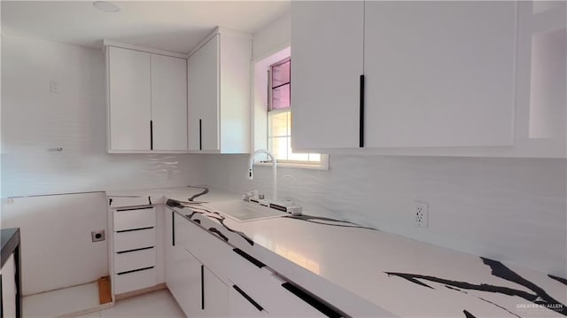 kitchen with white cabinetry, sink, and tasteful backsplash