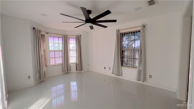 empty room featuring tile patterned floors and ceiling fan