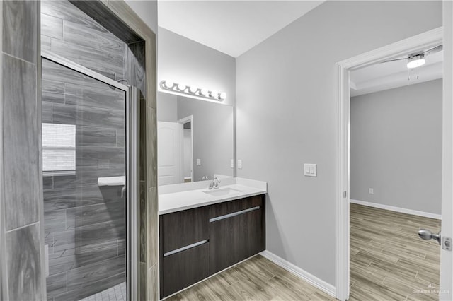 bathroom featuring a shower with door, vanity, and wood-type flooring