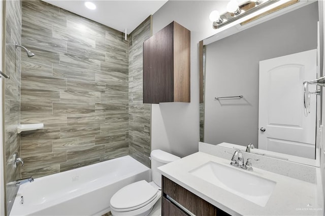 full bathroom with tiled shower / bath, vanity, and toilet