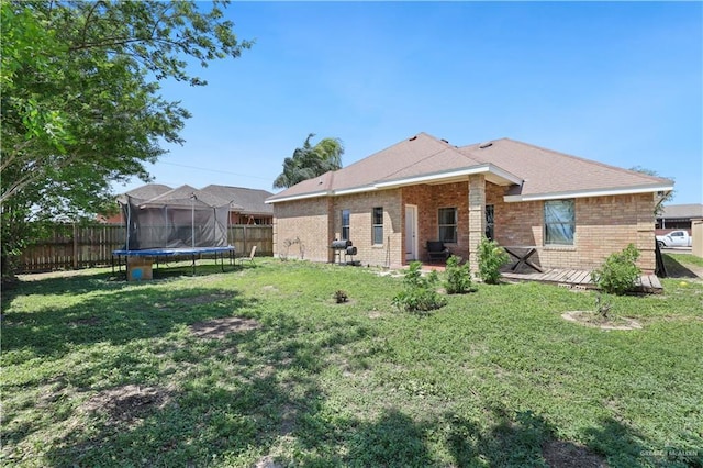 5212 N Huisache St, Pharr, TX 78577 - back of house featuring a yard, brick siding, a fenced backyard, and a trampoline