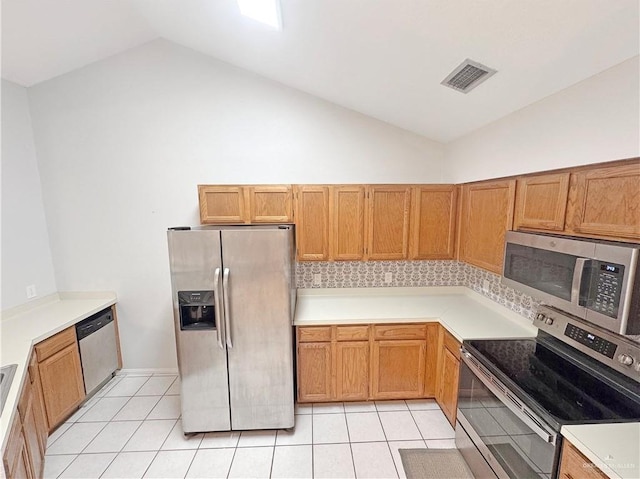 kitchen featuring visible vents, light tile patterned floors, light countertops, lofted ceiling, and stainless steel appliances