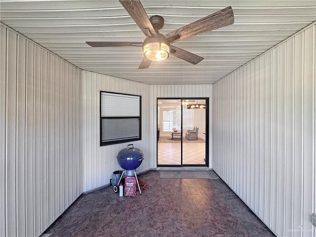 unfurnished sunroom with a ceiling fan