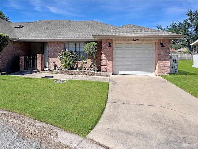 ranch-style home featuring brick siding, a shingled roof, a front lawn, and concrete driveway