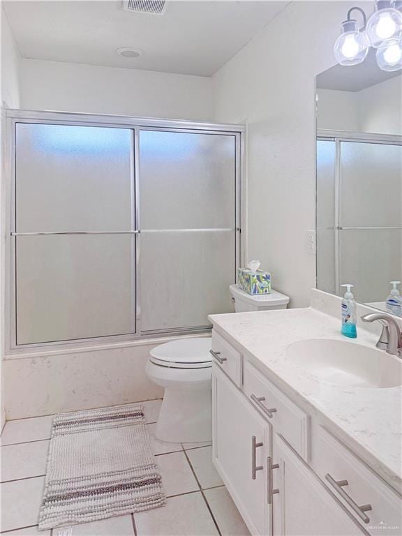 bathroom featuring visible vents, tile patterned flooring, vanity, combined bath / shower with glass door, and toilet
