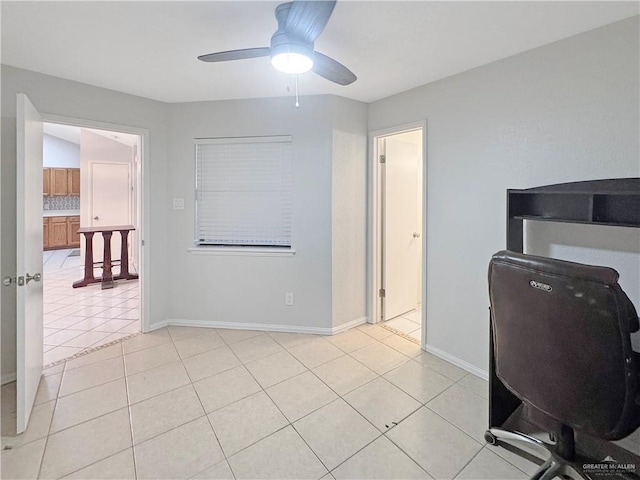 office featuring a ceiling fan, baseboards, and light tile patterned floors