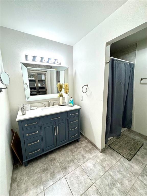 full bathroom with vanity, a shower with shower curtain, and tile patterned flooring