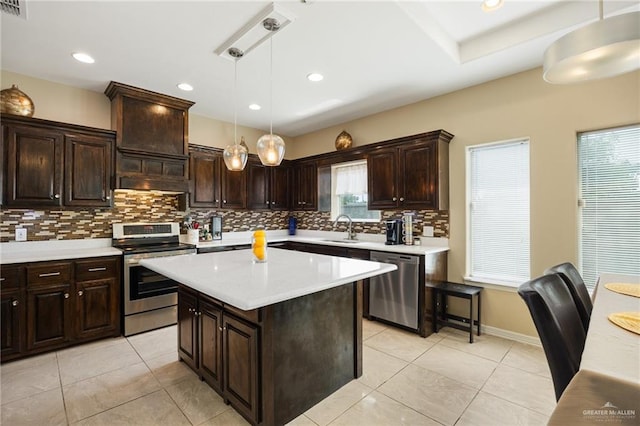 kitchen featuring a center island, backsplash, sink, hanging light fixtures, and stainless steel appliances