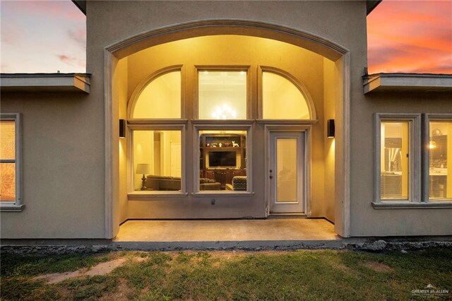 597 Greystone Cir, Alamo, TX 78516 - exterior entry at dusk with stucco siding
