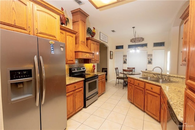 907 Amethyst Dr, Weslaco, TX 78596 - kitchen with appliances with stainless steel finishes, arched walkways, a sink, light tile patterned flooring, and decorative backsplash