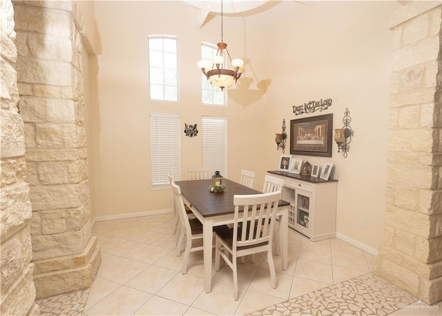 907 Amethyst Dr, Weslaco, TX 78596 - dining room featuring a chandelier, light tile patterned floors, a towering ceiling, and baseboards