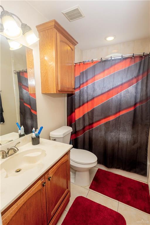 907 Amethyst Dr, Weslaco, TX 78596 - bathroom featuring toilet, vanity, tile patterned flooring, and a shower with curtain